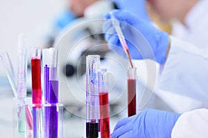 Young male Laboratory scientist working at lab with test tubes and microscope, test or research in clinical laboratory.