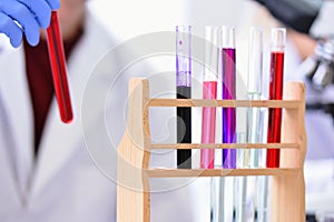 Young male Laboratory scientist working at lab with test tubes and microscope, test or research in clinical laboratory.