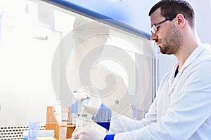 Young male Laboratory scientist working at lab with test tubes and microscope, test or research in clinical laboratory.Science,