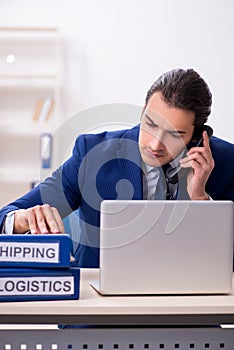 Young male logistics specialist working in the office