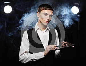 Young male make up artist holding shadow palette and brush.