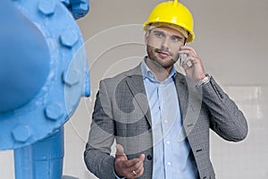 Young male manager using smart phone in industry