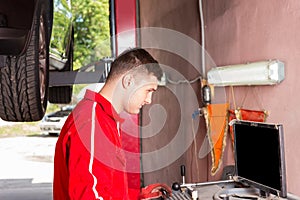 Young male mechanic checking the readout