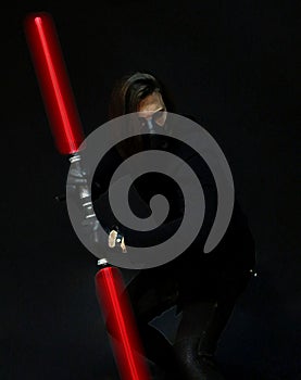 Young male model with mask posing with light saber. Fantasy, Halloween, Sci-Fi concept.