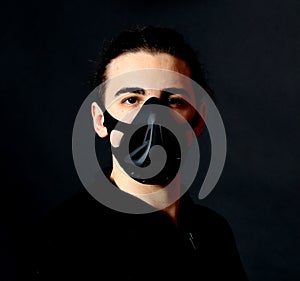 Young male model with mask posing in studio. Fantasy, Halloween, Sci-Fi concept.