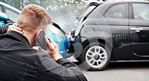 Young Male Motorist Involved In Car Accident Calling Insurance Company Or Recovery Service