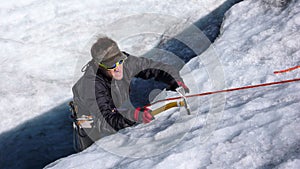 A young male mountain guide candidate training ice axe and rope skills on a glacier in the Swiss Alps