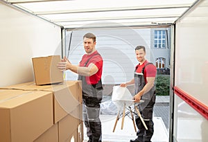 Young Male Movers Arranging The Products In Van