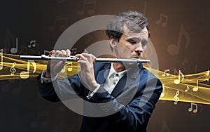 Musician playing on flute with notes around photo