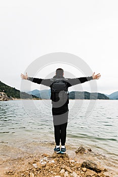 Young male nature explorer enjoying the view of the lake