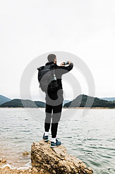 Young male nature explorer enjoying the view of the lake