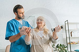 young male nurse helping senior woman photo