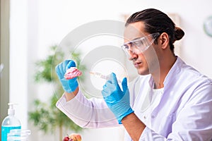 Young male nutrition expert testing food products in lab