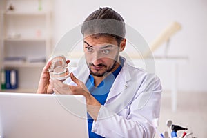 Young male odontologist in telemedicine concept photo