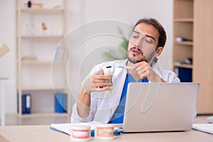 Young male odontologist in telemedicine concept photo