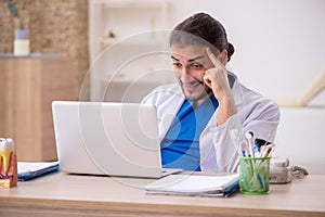 Young male odontologist in telemedicine concept photo