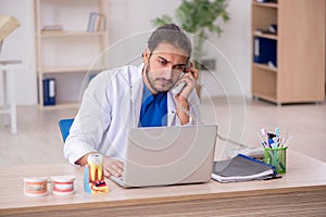 Young male odontologist in telemedicine concept photo