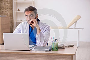 Young male odontologist in telemedicine concept photo