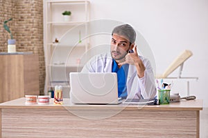 Young male odontologist in telemedicine concept photo