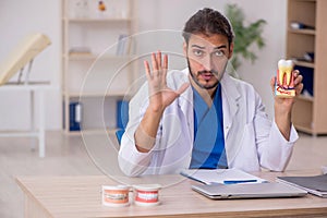 Young male odontologist working in the clinic