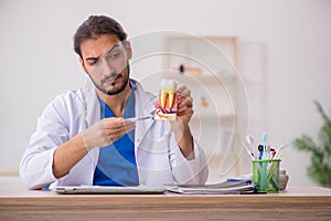 Young male odontologist working in the clinic photo