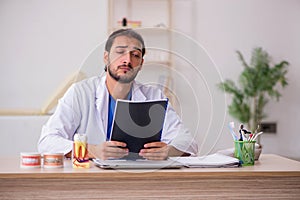 Young male odontologist working in the clinic photo