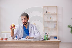 Young male odontologist working in the clinic photo