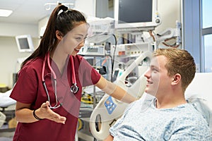 Young Male Patient Talking To Female Nurse In Emergency Room