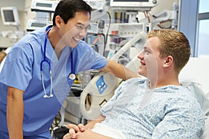 Young Male Patient Talking To Male Nurse In Emergency Room