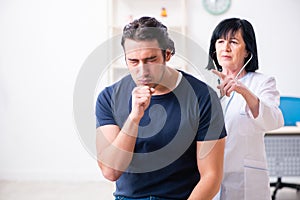 The young male patient visiting aged female doctor