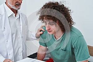 Young male patient visiting experienced doctor while having injury