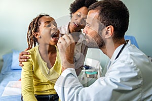 Young male pediatrician doctor examining child at office. Healthcare prevention exam people concept