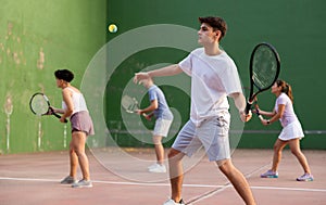 Young male pelota player hitting ball with racket photo
