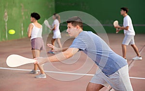 Young male pelota player hitting ball with racket photo