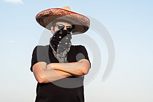 Young male person dressed up as gangster in traditional sombrero