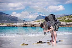 Mladý samec fotograf dredy na slnečný biely piesok pláž, ostrovček z, škótsko 