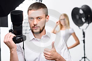 Young male photographer showing thumbs up