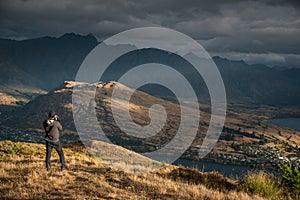 Young male photographer taking photo of scenery in Queenstown