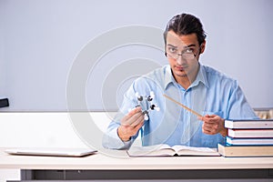 Young male physics teacher in front of whiteboard