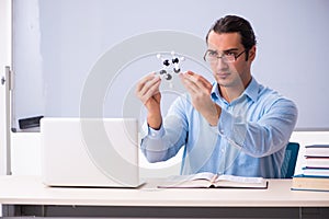 Young male physics teacher in front of whiteboard