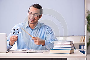 Young male physics teacher in front of whiteboard