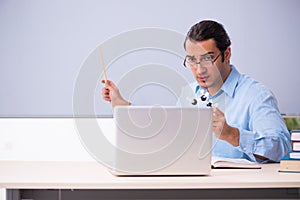 Young male physics teacher in front of whiteboard