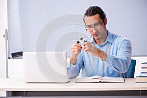 Young male physics teacher in front of whiteboard