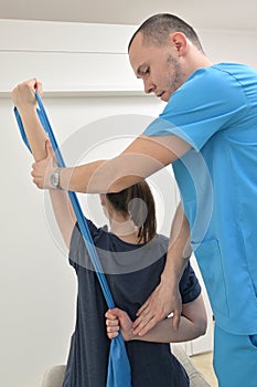 A young male physiotherapist helping a girl with stretching exercises