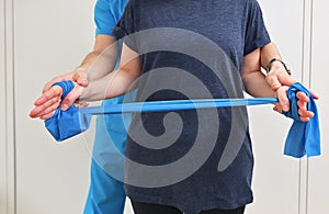 A young male physiotherapist helping a girl with stretching exercises