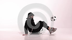 Young male player juggles football ball on white studio on the floor. Caucasian professional football soccer player. Man