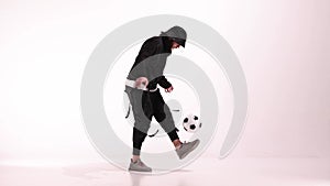 Young male player juggles football ball on white studio on the floor. Caucasian professional football soccer player. Man