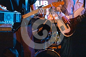 Young male playing on a guitar during a concert