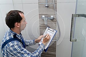 Plumber Checking Faucet In Shower photo