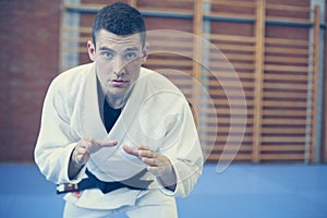 Young male practicing judo in kimono.